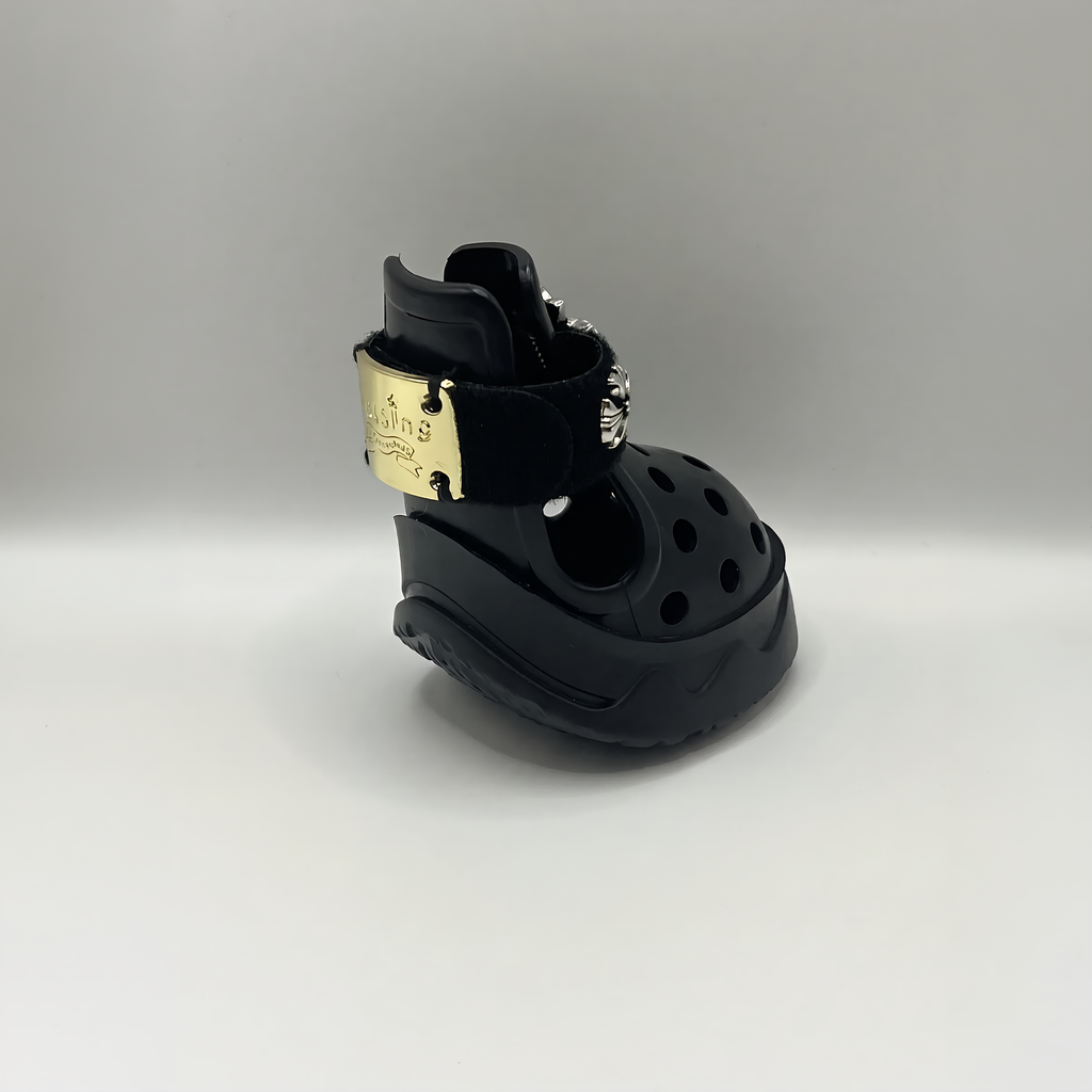 Rear quarter view of a single black BLESSING dog sandal, showcasing the secure heel support and gold metal buckle detail.