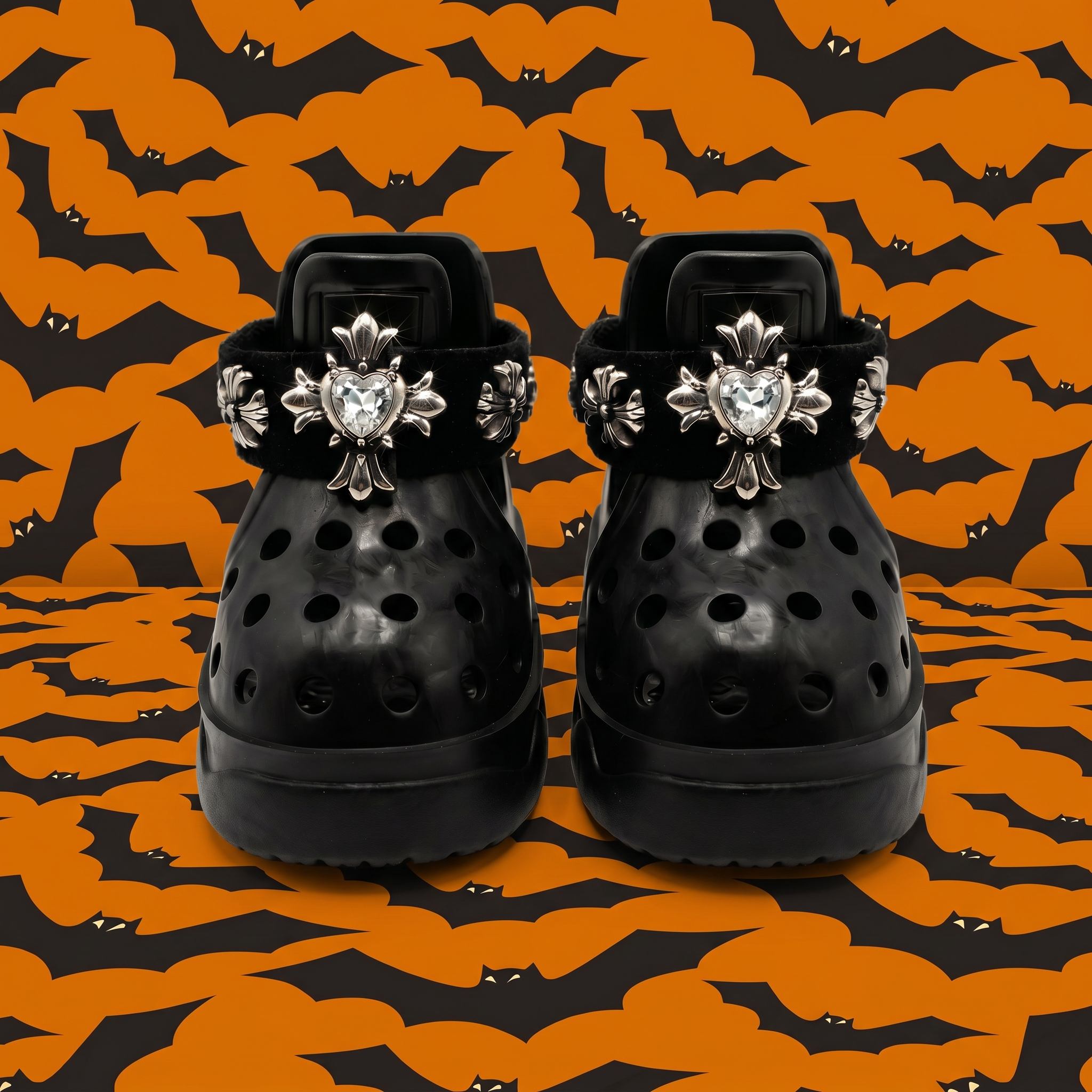 Front view of a pair of BLESSING Halloween limited edition dog sandals in obsidian black, featuring hand-sewn punk silver crosses with heart jewels against an orange bat background.