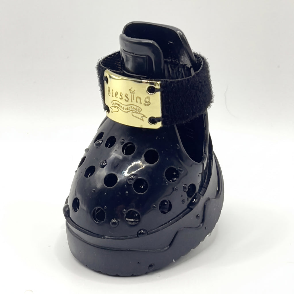 Macro closeup shot of a single Blessingmychild V1 classic knight black pet croc with the signature shiny front gold brand plate