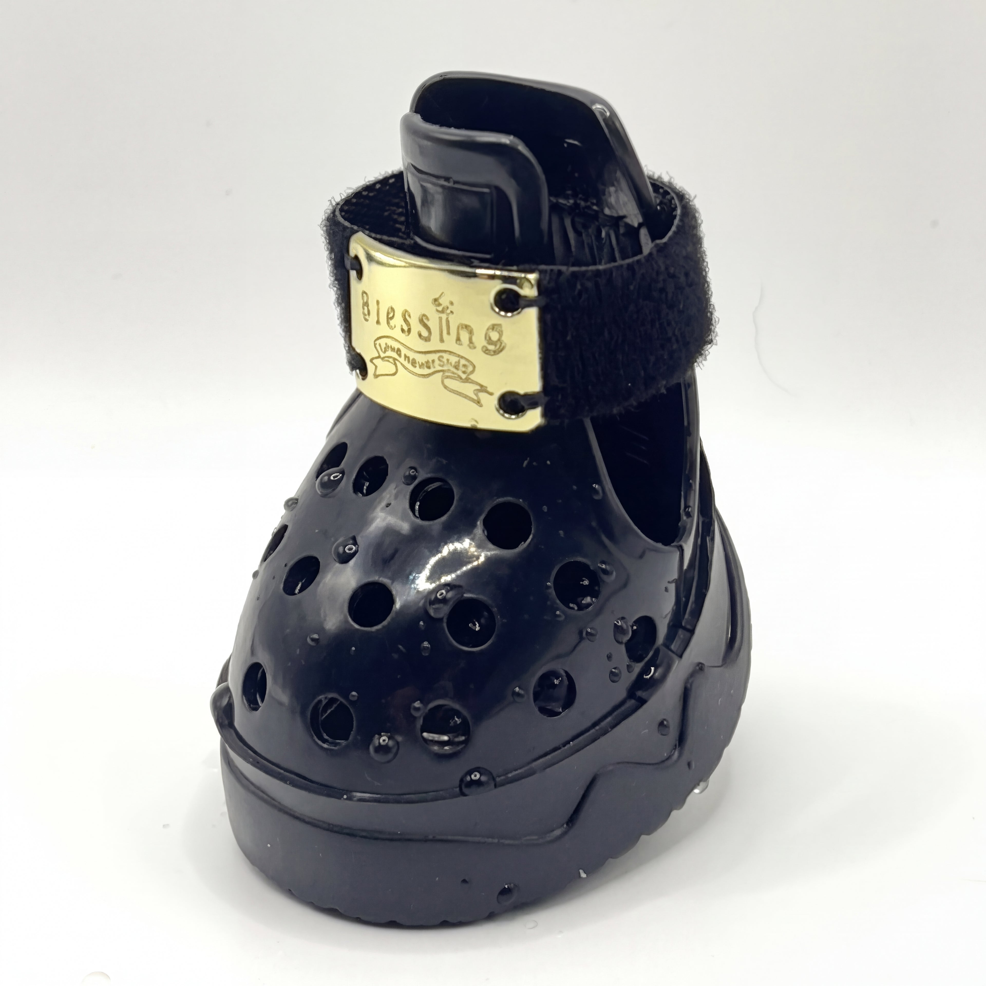 Macro closeup shot of a single Blessingmychild V1 classic knight black pet croc with the signature shiny front gold brand plate