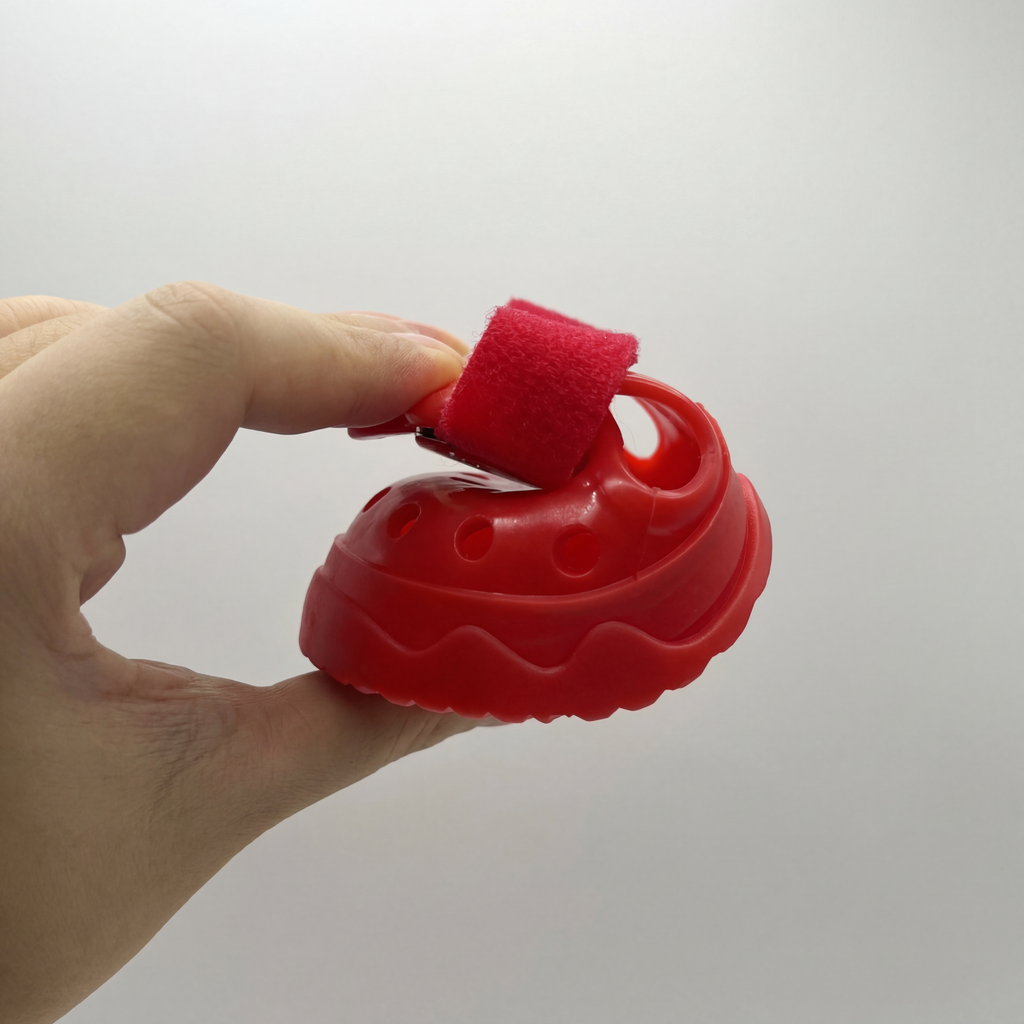 Hand squeezing a Blessingmychild V1 red dog shoe to demonstrate the flexible premium soft sole and lightweight architecture