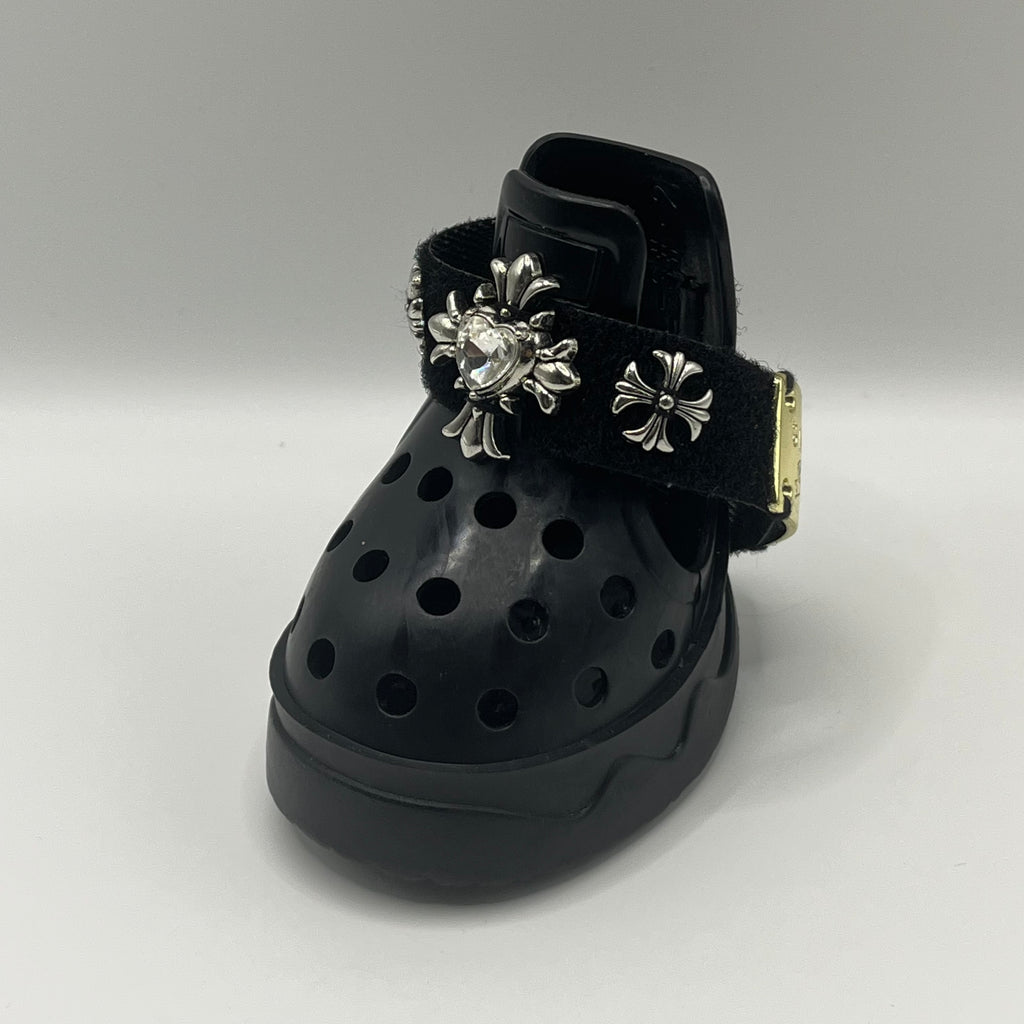 Front close-up view of BLESSING black punk style dog sandal, featuring the intricate hand-sewn chrome heart and cross emblem.