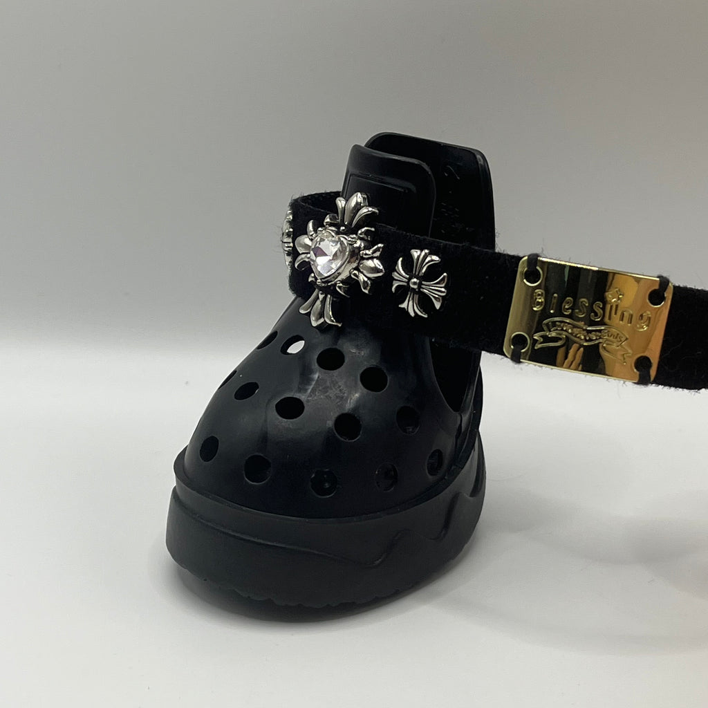 Side angle view of BLESSING black rubber dog sandal with its adjustable gold-toned metal buckle strap extended.